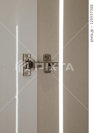 The installation process of a modern door hinge, showcasing elegance and light reflection 120557388