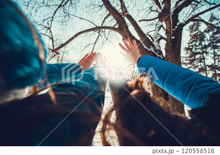A group of little boys and girls in colorful clothes play outdoors during snowfall. Active vacation with children in winter on cold days. Happy siblings and twins having fun with snow 120558516
