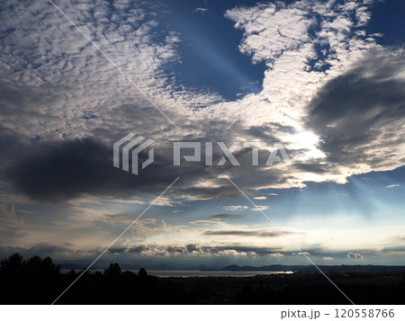 猪苗代湖上空の雲が太陽で白く輝く。切れ間から光が放射状に広がり、湖面を輝かせ、印象的で綺麗だ。 120558766