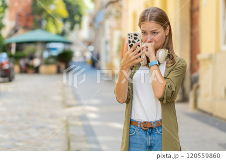 Upset young woman using smartphone loses becoming surprised sudden lottery results on city street Upset young woman using smartphone loses becoming surprised sudden lottery results on city street 120559860