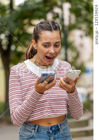 Irritated stressed business woman talking on two mobile phones having conversation conflict quarrel Irritated stressed business woman talking on two mobile phones having conversation conflict quarrel 120559924