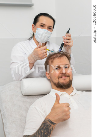 Trichologist doing man improve hair growth procedure, dermapen microneedling, vitamin injections Trichologist doing man improve hair growth procedure, dermapen microneedling, vitamin injections 120560010