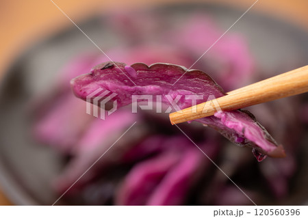 お箸で摘まんだしば漬けのクローズアップ お箸で摘まんだしば漬けのクローズアップ 120560396