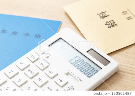 130万と表示された電卓と年金手帳 120561487
