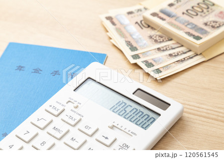 106万と表示された電卓と年金手帳 120561545