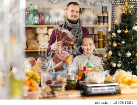 Man and boy choose dried meat in grocery 120561629