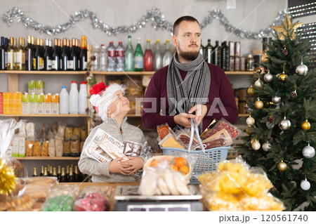 Young man with son choosing products in grocery store Young man with son choosing products in grocery store 120561740