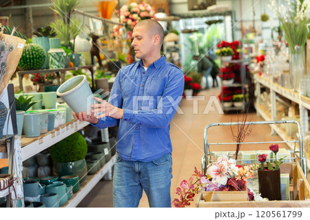 Man picking flower pot in store Man picking flower pot in store 120561799