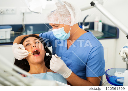 Dentist examining asian female patient teeth 120561899