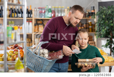 Young man with son buying groceries from shopping list 120561988