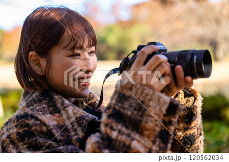 紅葉を撮影するカメラ女子 120562034