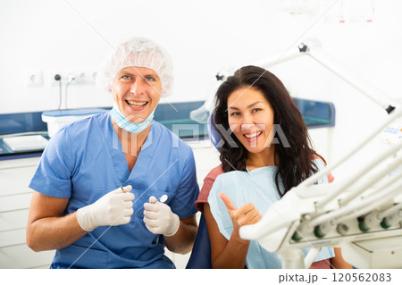 Satisfied patient visiting dentist giving thumbs up Satisfied patient visiting dentist giving thumbs up 120562083