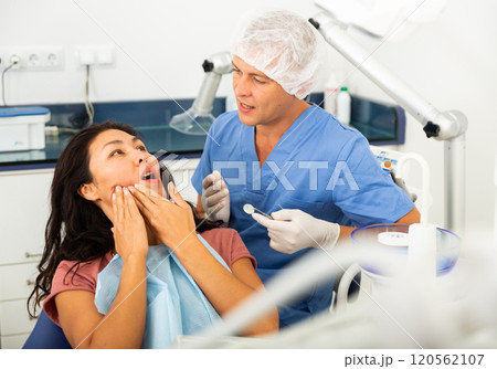Woman patient showing which side she has a toothache Woman patient showing which side she has a toothache 120562107