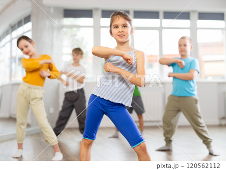 Girl learn to dance hip hop dances, doing movement with unrecognizable teacher. 120562112