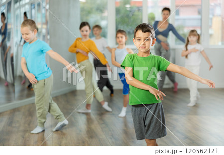 Group of happy preteen children with female teacher practicing hip hop in dance studio 120562121