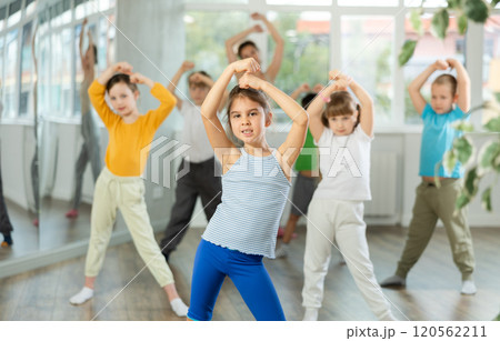 Girl learn to dance modern dances, doing movement with unrecognizable teacher. 120562211