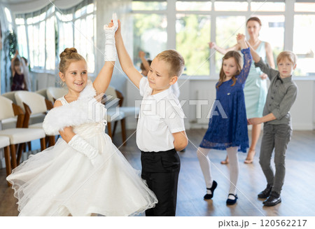 Enthusiastic preteen children dancing waltz in pairs in dance school Enthusiastic preteen children dancing waltz in pairs in dance school 120562217
