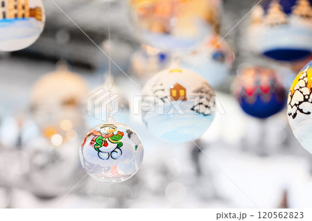 Christmas tree baubles hanging on christmas market stall, festive decorations 120562823
