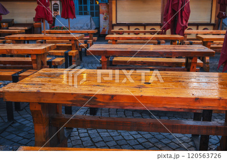 wooden tables and benches in a street cafe in evening in the rain wooden tables and benches in a street cafe in evening in the rain 120563726