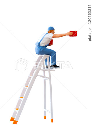 A miniature figurine of a painter seated on a ladder, holding a paint can and brush isolate on white back ground with clipping path 120563852