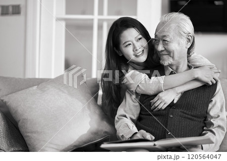 elderly asian father and adult daughter conversing at home elderly asian father and adult daughter conversing at home 120564047