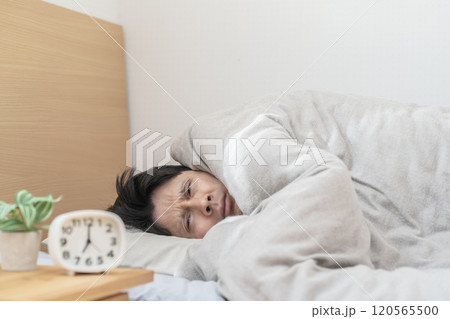ベッドで眠る男性 寒くてベッドから出られない男性 ベッドで眠る男性 寒くてベッドから出られない男性 120565500