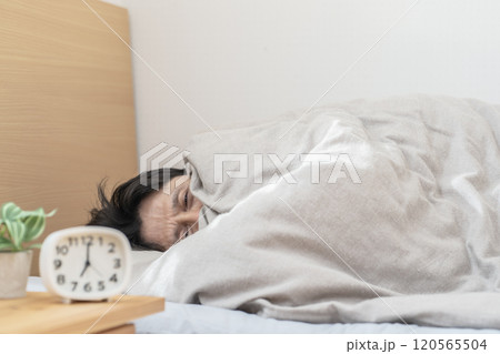 ベッドで眠る男性　寒くてベッドから出られない男性 120565504