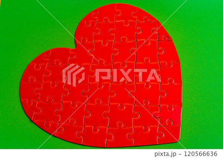 Feelings concept. Heart puzzle on green background 120566636