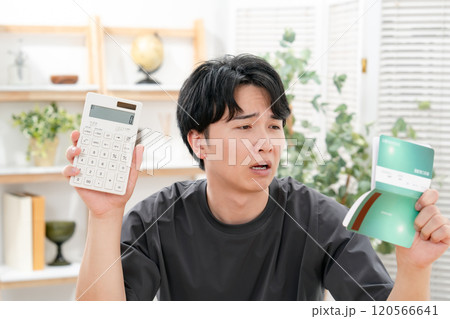 通帳を持って悩む男性 通帳を持って悩む男性 120566641