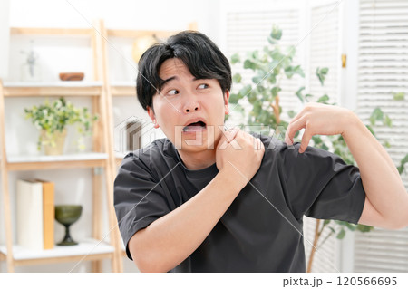 男性　カジュアル　肩こり 120566695