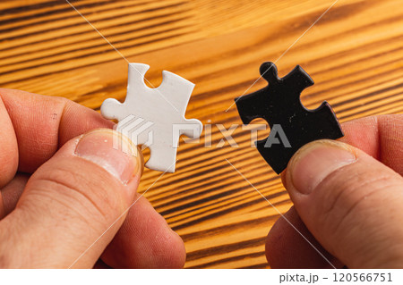 Hands holding black and white puzzle, concept of difficult option choice 120566751