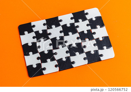 Black and white puzzle, teamwork challenge concept on orange background. Black and white puzzle, teamwork challenge concept on orange background. 120566752