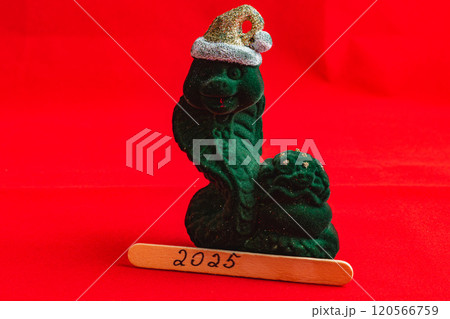 Green snake figurine in a hat with a wooden stick for the new year 2025 Green snake figurine in a hat with a wooden stick for the new year 2025 120566759