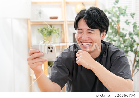 スマホを見て笑う男性 スマホを見て笑う男性 120566774