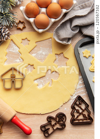 Baker is preparing christmas cookies using dough cutters and baking tray 120567382