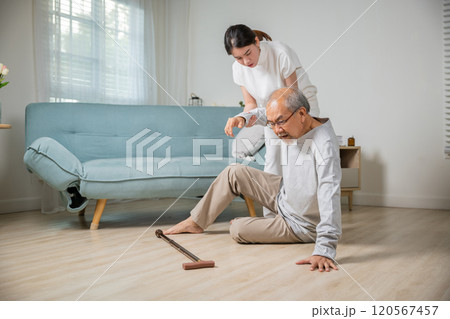Asia young woman halping her father after falling down on floor, elderly old man with walking stick fall on ground and daughter camp to help at home in living room, family health care 120567457