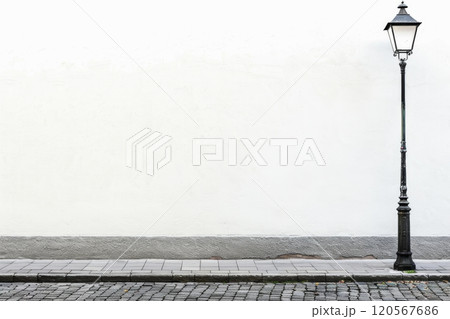 Vintage street lamp next to a blank white wall in a quiet alley Vintage street lamp next to a blank white wall in a quiet alley 120567686