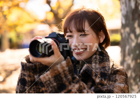 紅葉を撮影するカメラ女子 120567925