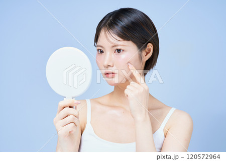 肌の様子を確かめる若い女性 120572964