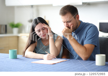 Sad interracial couple or roommates reading contract 120572993