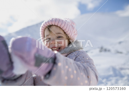 Portrait of small girl enjoying winter holiday in the mountains with family, playing in snow. Portrait of small girl enjoying winter holiday in the mountains with family, playing in snow. 120573160