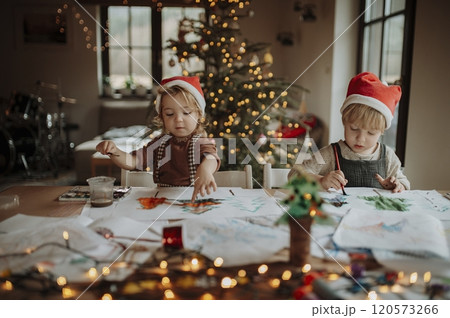 Siblings making holiday Christmas cards for family. Children painting pictures for Santa Claus or making christmas decorations with watercolors. Siblings making holiday Christmas cards for family. Children painting pictures for Santa Claus or making christmas decorations with watercolors. 120573266