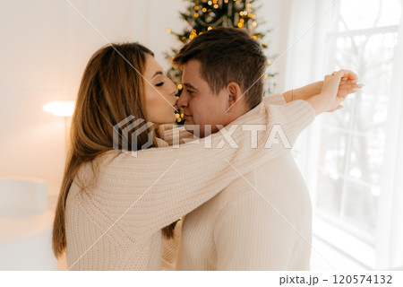 Picture showing young couple hugging over Christmas tree 120574132