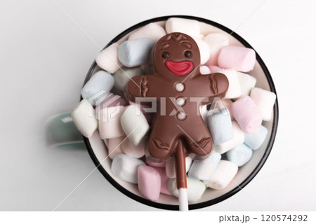 Chocolate man on marshmallow cup, sweet Christmas cookies, close-up, top view 120574292