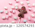 Chocolate man on pink background with marshmallows , sweet Christmas cookies, top view 120574293