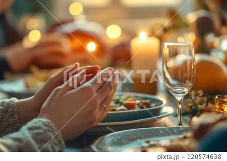 Closeup of Hands Clasped in Prayer During a Festive Meal 120574638