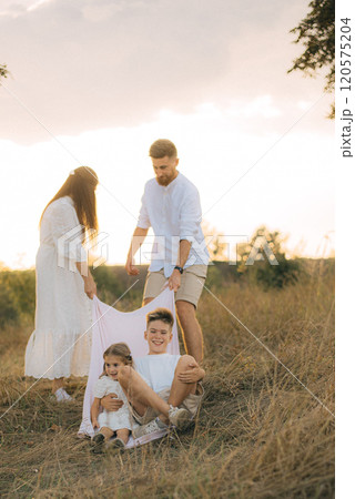 Happy young family dad, mom and two children playing outdoors, having fun on a day off. 120575204
