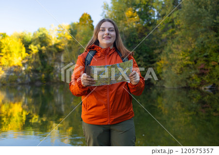 Traveling Happy Caucasian woman with backpack walking on path the mountain forest looking at the camera and map. Summer holiday and vacation trip Traveling Happy Caucasian woman with backpack walking on path the mountain forest looking at the camera and map. Summer holiday and vacation trip 120575357