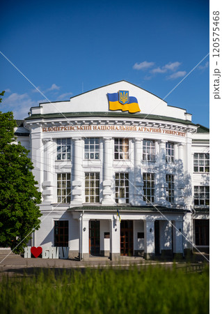 The photo shows a white building with columns, the Ukrainian flag, and the name "Bila Tserkva National Agrarian University." A sign reading "I love BNAU" is visible in the foreground. 120575468