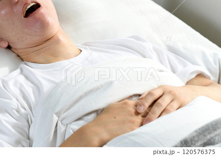 ベッドの上で口を開けて寝るアジア人男性 120576375